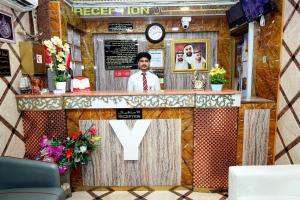 a man standing at a counter in a restaurant at Al Khaima Hotel in Dubai