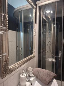 a bathroom with a sink with a mirror and a shower at Siófok 7 Apartmanház in Siófok +70 photos