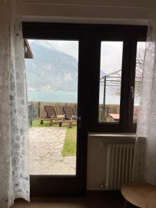 a room with a window with a view of the ocean at Cà Serena Panoramic Garden - Appartamento Greta in Ledro