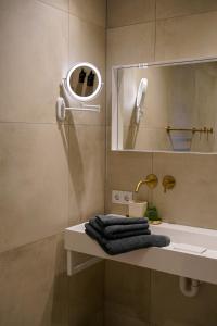 a bathroom with a sink and a mirror and towels at Landgoed Erve Triesthaar in De Lutte +47 photos