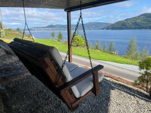 a swing hanging from a porch overlooking a lake at Large house with panoramic sea view in Bergen +26 photos