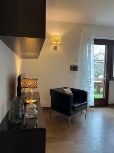 a living room with a black chair and a table at Cà Serena Panoramic Garden - Appartamento Greta in Ledro