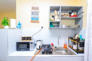 a small kitchen with a sink and a microwave at A&M Luxury bnbs in Nairobi