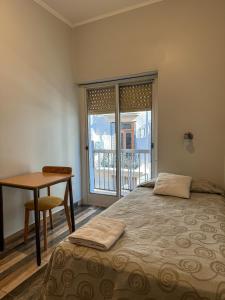 a bedroom with a bed and a desk and a window at Hotel Europa in Buenos Aires