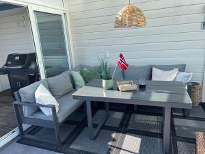 a table and a couch on a patio at Large house with panoramic sea view in Bergen