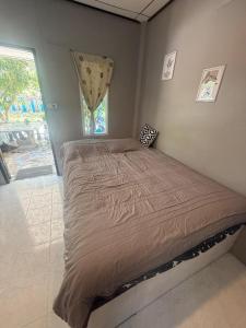 a large bed in a bedroom with a window at Karaked House in Chaloklum