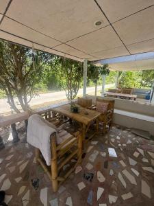 a dining table and chairs under an umbrella at Karaked House in Chaloklum