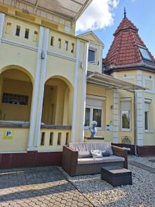 a couch sitting in the courtyard of a building at Siófok 7 Apartmanház in Siófok