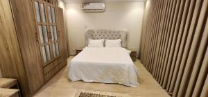 a bedroom with a bed with white sheets and pillows at شقق قاردينيا in Aş Şafā +15 photos