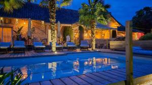 a house with a swimming pool and palm trees at Domaine Kaet in Ratenelle