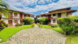 a courtyard of a house with a stone path at finca hotel palmas frente a panaca in Quimbaya
