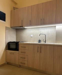 a kitchen with wooden cabinets and a microwave at MINAS CENTRAL apartments in Heraklio