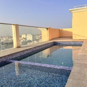 a swimming pool on the roof of a building at Almasar Hotel in Maţār as Sīb ad Duwalī