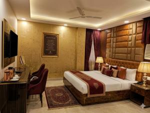 a hotel room with a bed and a desk and a television at Hotel Krone International in Gurgaon +22 photos