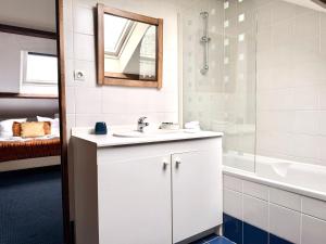 a bathroom with a sink and a tub and a mirror at Le duplex - Cosy & Pratique in Gastins +10 photos