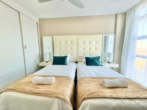 two beds sitting next to each other in a bedroom at Relaxing Blouberg Beachfront view Apartment in Cape Town