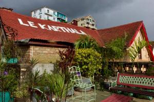 a building with a red roof and a bench at Le Karthala in Antananarivo