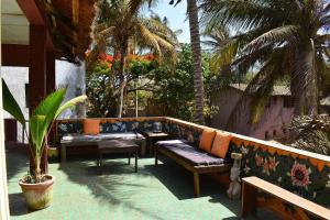 a patio with benches and palm trees and palm trees at Casa Jujube - Guest House in Dakar