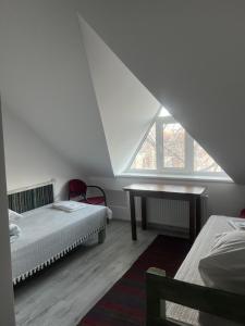 a attic room with two beds and a desk at Hanul lui Hanganu in Lalova
