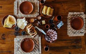 a wooden table topped with plates of food and wine at Hanul lui Hanganu in Lalova +6 photos