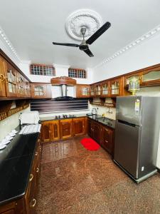 a kitchen with wooden cabinets and a stainless steel refrigerator at Gem Palace in Perumpāvūr