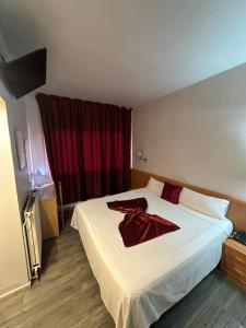 ein Hotelzimmer mit einem Bett, auf dem ein roter Bademantel liegt in der Unterkunft Hotel Norai in Lloret de Mar