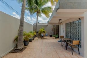 a patio with palm trees and a table and chairs at CASA EN EL CENTRO & CORAZON DE CANCUN in Cancún