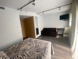 a bedroom with a zebra print bed and a couch at Hotel 9 Sant Antoni Only Adults in Ribes de Freser