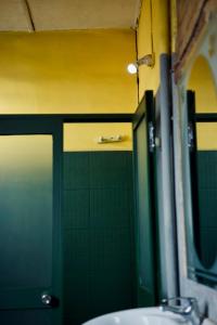 a bathroom with a sink and a green wall at Le Karthala in Antananarivo