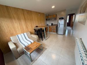 a living room with a couch and a kitchen at Nomade Aparts in El Chalten