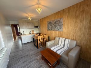 a living room with a couch and a table and a kitchen at Nomade Aparts in El Chalten