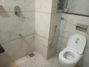 a bathroom with a toilet and a shower at The Nature Park Hotel in Mudhol +5 photos
