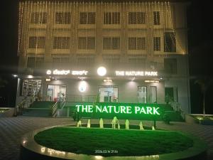 a sign in front of the nature park at night at The Nature Park Hotel in Mudhol