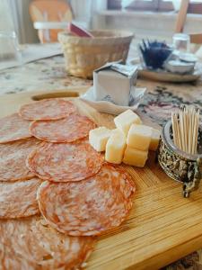 a table with pancakes and cheese on a cutting board at B&B Villa Adriano in Cavaion Veronese