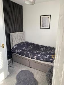 a bedroom with a bed with a black and white comforter at Garden view Cosy Single Room in Derby