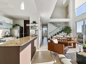 a kitchen and living room with a counter and a dining room at Depa Penthouse en Juriquilla con terraza y alberca climatizada in Juriquilla