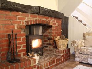 a brick fireplace with a stove in a living room at Brook House 2 - Uk31043 in Bassenthwaite