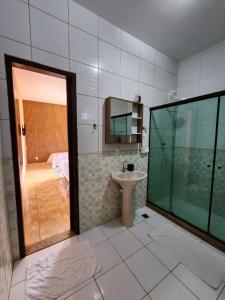 a bathroom with a sink and a shower with a mirror at Espaço Sunshine in Saquarema +38 photos