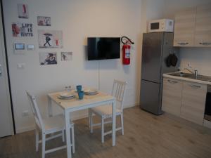 a small kitchen with a table and a refrigerator at Guest House Il Colibri' in Bologna