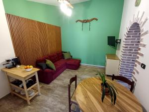 a living room with a red couch and a table at Podere Al Covo - House, Garden & Vineyard - Alghero in Alghero