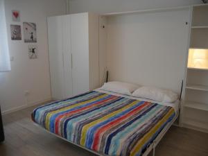 a bedroom with a bed with a colorful striped blanket at Guest House Il Colibri' in Bologna