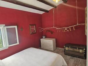 a bedroom with red walls and a bed and a window at Podere Al Covo - House, Garden & Vineyard - Alghero in Alghero