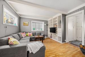 a living room with a couch and a tv at Hovedhuset in Kragerø