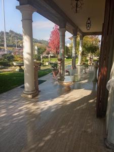 an outdoor patio with columns and potted plants at B&B Villa Adriano in Cavaion Veronese