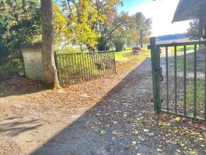 a fence with a tree next to a field at Le duplex - Cosy & Pratique in Gastins