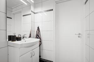 a white bathroom with a sink and a shower at Hovedhuset in Kragerø +9 photos