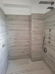 a bathroom with a shower with a wooden wall at Casa Al Vento in Lucignano