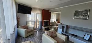 a living room with two chairs and a flat screen tv at Апартамент При Рени in Koprivshtitsa +63 photos