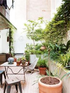 a patio with a table and chairs and plants at Ostello City In Hostel B&B in Catania
