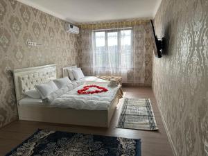 a bedroom with a bed and a window at Welcome home apartments in Samarkand